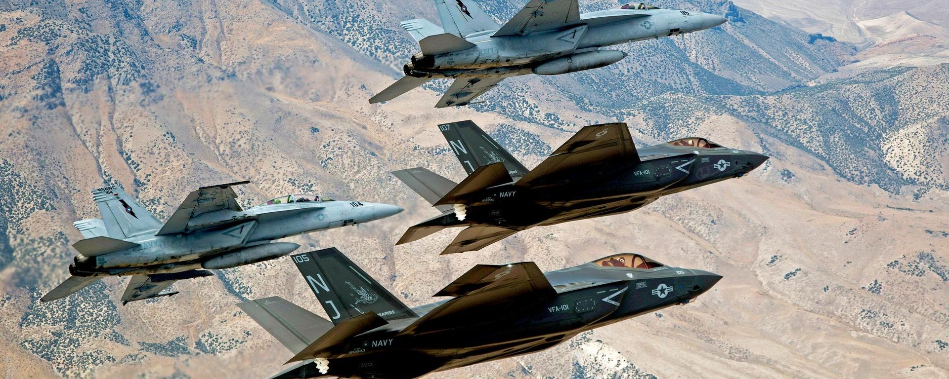 In this Sept. 3, 2015, file photo provided by the US Navy, F-35C Lightning IIs, attached to the Grim Reapers of Strike Fighter Squadron (VFA) 101, and F/A-18E/F Super Hornets attached to the Naval Aviation Warfighter Development Center (NAWDC) fly over Naval Air Station Fallon's (NASF) Range Training Complex near Fallon - Sputnik International, 1920, 08.07.2026