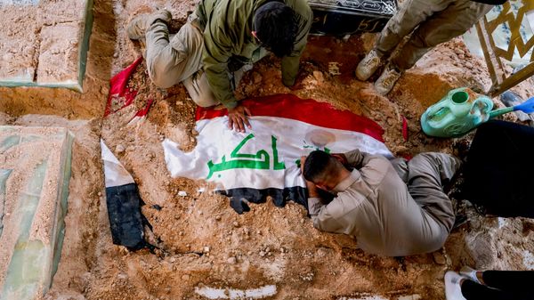 Mourners grieve at the grave of a Popular Mobilization Forces fighter during a funeral for fighters killed in airstrikes on PMF bases in Najaf, Iraq, Thursday, July 30, 2026. - Sputnik International