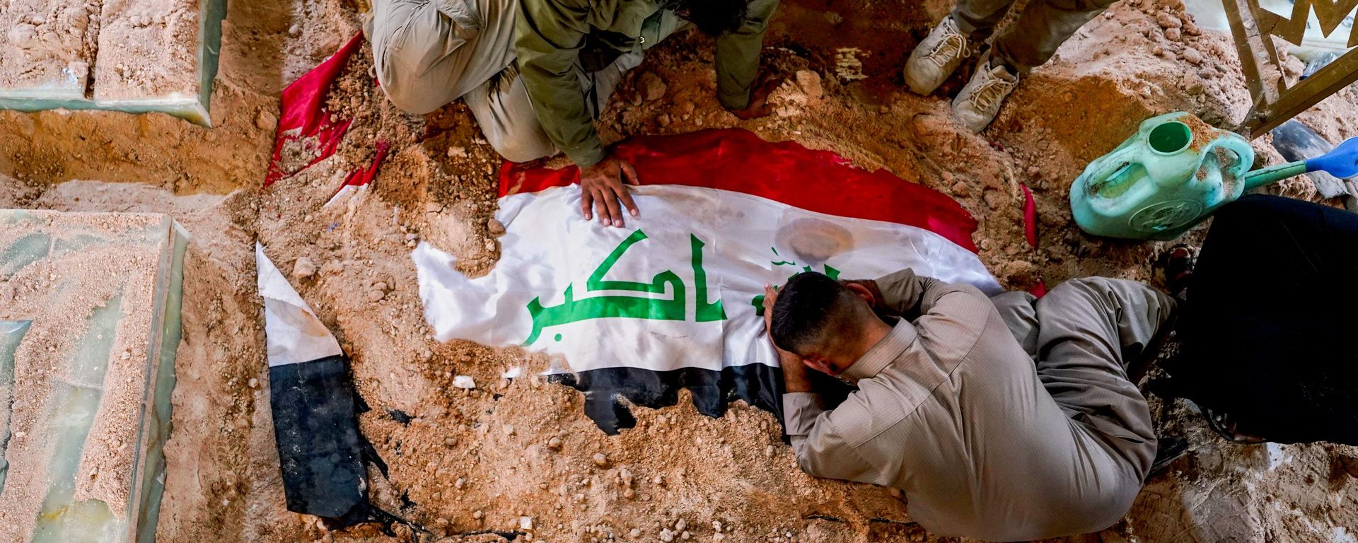 Mourners grieve at the grave of a Popular Mobilization Forces fighter during a funeral for fighters killed in airstrikes on PMF bases in Najaf, Iraq, Thursday, July 30, 2026. Mourners grieve at the grave of a Popular Mobilization Forces fighter during a funeral for fighters killed in airstrikes on PMF bases in Najaf, Iraq, Thursday, July 30, 2026. - Sputnik International, 1920, 29.07.2026