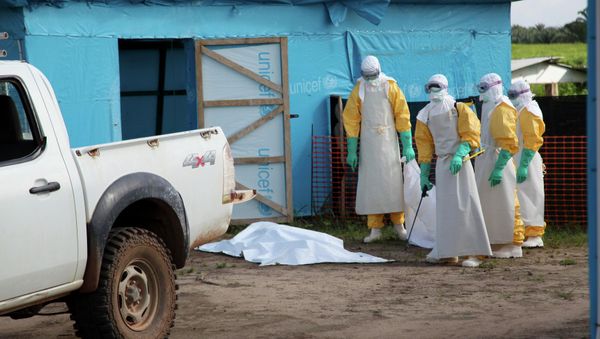 Medical workers by an isolation tent housing those infected with Ebola, Liberia. Medical workers by an isolation tent housing those infected with Ebola, Liberia. - Sputnik International