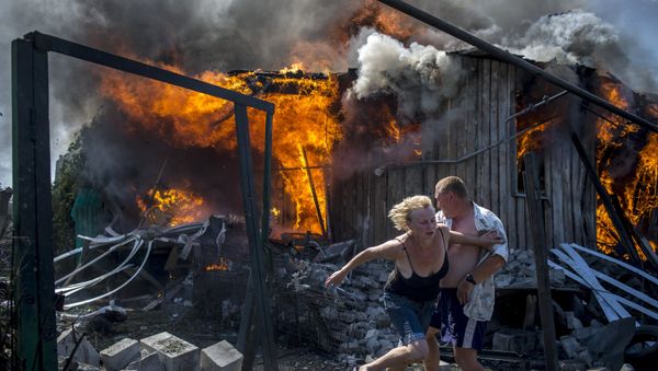 Local residents flee from a burning home hit by an air strike by the Ukrainian armed forces in Lugansk. Local residents flee from a burning home hit by an air strike by the Ukrainian armed forces in Lugansk. - Sputnik International
