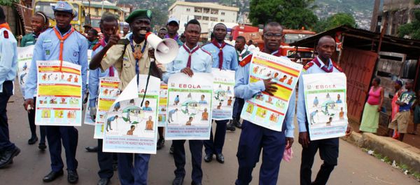 UNICEF members are holding posters detailing Ebola virus symptoms, Freetown, Sierra Leone. - Sputnik International