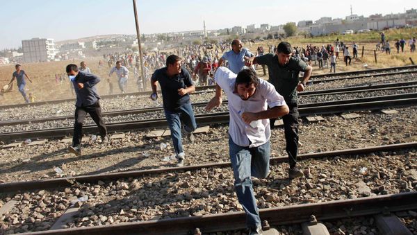 Turkish and Syrian Kurds run as Turkish security forces use tear gas to disperse them near the Mursitpinar border crossing on the Turkish-Syrian border, near the southeastern town of Suruc September 26, 2014. - Sputnik International
