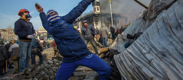 A protester throws stone on Maidan square in Kiev, Ukraine, Feb 19, 2014 A protester throws stone on Maidan square in Kiev, Ukraine, Feb 19, 2014 - Sputnik International