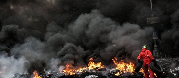 A protester adds tire to the fire in Maidan square in Kiev, Ukraine, Jan 22, 2014 - Sputnik International