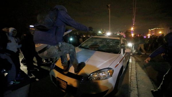 Protesters vandalize a police car outside the Ferguson Police Department in Ferguson, Missouri, after a grand jury returned no indictment in the shooting of Michael Brown - Sputnik International