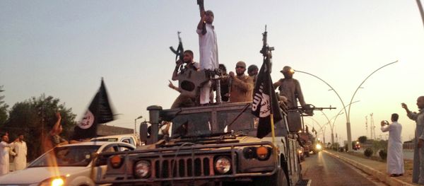 Fighters from the Islamic State group parade in a commandeered Iraqi security forces armored vehicle down a main road at the northern city of Mosul, Iraq - Sputnik International
