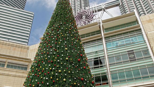 People walk around a giant Christmas tree on display against the Malaysia's landmark Petronas Twin Towers in Kuala Lumpur, Malaysia, Dec. 6, 2014 - Sputnik International