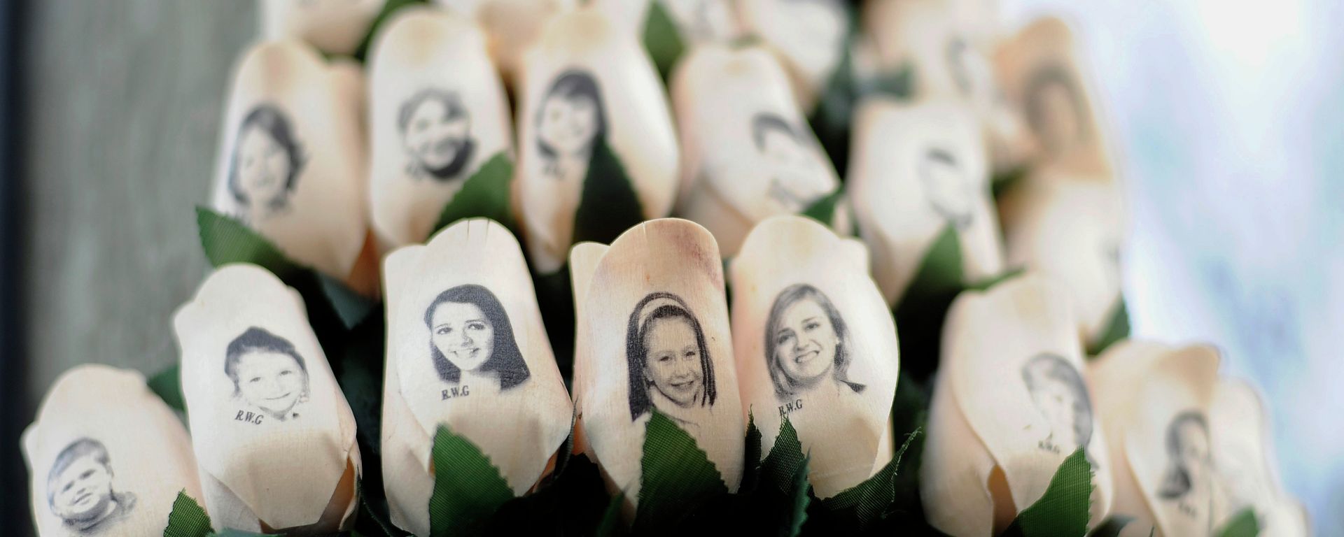 In this Jan. 14, 2013 file photo, white roses with the faces of victims of the Sandy Hook Elementary School shooting are attached to a telephone pole near the school on the one-month anniversary of the shooting that left 26 dead in Newtown, Conn. In this Jan. 14, 2013 file photo, white roses with the faces of victims of the Sandy Hook Elementary School shooting are attached to a telephone pole near the school on the one-month anniversary of the shooting that left 26 dead in Newtown, Conn. - Sputnik International, 1920, 14.12.2022
