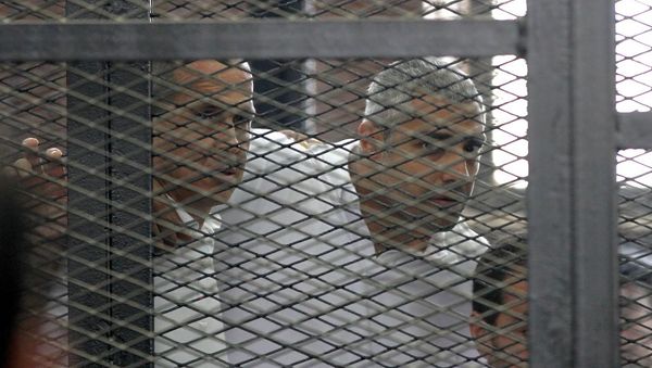 Australian journalist Peter Greste and Mohamed Fahmy stand inside court's cage 23 Jun 2014 - Sputnik International