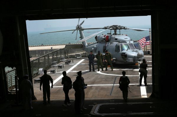 U.S. Navy officers are silhouetted against the flight deck of the U.S. Navy ship USS Freedom (LCS 1) berthed at the Changi Naval Base on Thursday April 18, 2013 in Singapore. USS Freedom (LCS 1) is on a port call here.  - Sputnik International