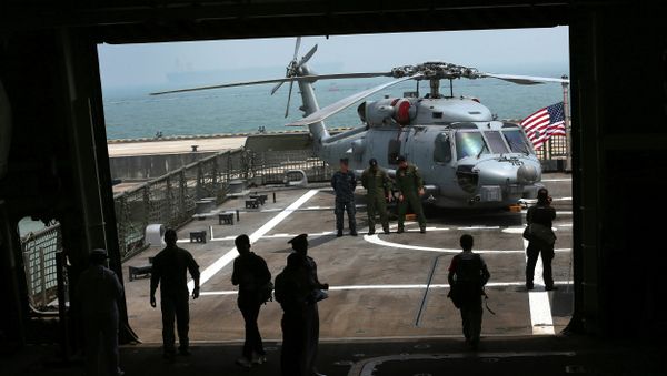 U.S. Navy officers are silhouetted against the flight deck of the U.S. Navy ship USS Freedom (LCS 1) berthed at the Changi Naval Base - Sputnik International