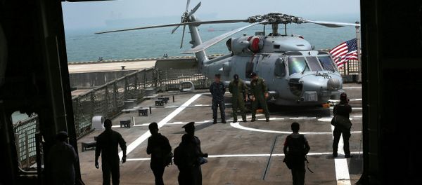 U.S. Navy officers are silhouetted against the flight deck of the U.S. Navy ship USS Freedom (LCS 1) berthed at the Changi Naval Base - Sputnik International