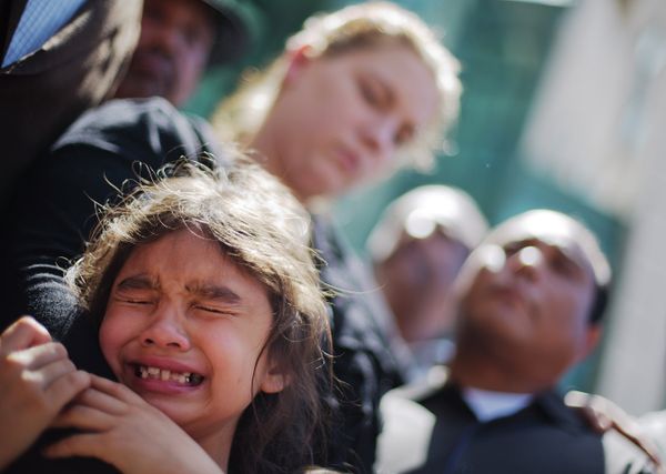 Emma Phonesavanh, the sister of 19-month-old Bounkham Bou Bou Phonesavanh who was severely burned by a flash grenade during a SWAT drug raid, cries while attending a vigil with her parents Alecia and Boun Khan Phonesavanh, rear left and right, outside Atlanta's Grady Memorial Hospital where he was undergoing treatment on June 2, 2014.  - Sputnik International