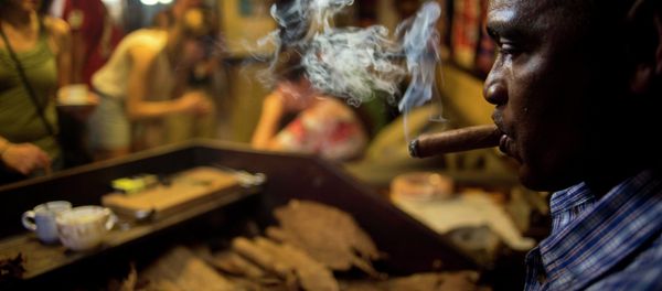 A worker rolls cigars during a demonstration for tourists at a cigar club shop in Havana, Cuba, Friday, Dec. 19, 2014. Cigars brought back to the U.S. must be for personal use, not resale - same as the rules that existed for travelers before August 2004, when the Bush administration imposed strict restrictions those traveling to the island. - Sputnik International