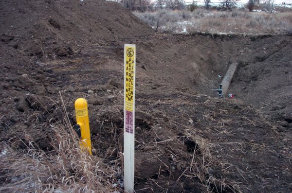 A warning sign shows the location of a 12-inch oil pipeline owned by Bridger Pipeline Co. that spilled up to 50,000 gallons of crude along the Yellowstone River near Glendive, Mont., Monday, Jan. 19, 2015.  - Sputnik International