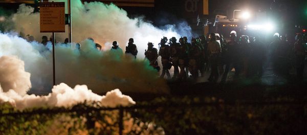 Riot police clear a street with smoke bombs while clashing with demonstrators in Ferguson, Missouri August 13, 2014. Riot police clear a street with smoke bombs while clashing with demonstrators in Ferguson, Missouri August 13, 2014. - Sputnik International