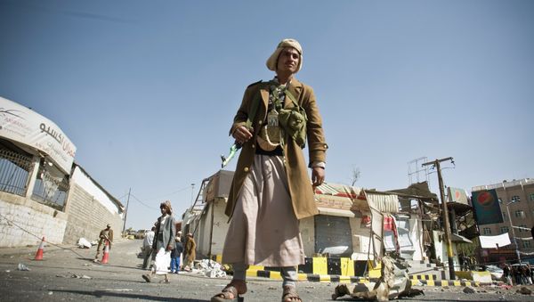 A Houthi Shiite Yemeni stands guard in front of a building damaged during recent clashes near the presidential palace in Sanaa, Yemen, Tuesday, Jan. 20, 2015. A Houthi Shiite Yemeni stands guard in front of a building damaged during recent clashes near the presidential palace in Sanaa, Yemen, Tuesday, Jan. 20, 2015. - Sputnik International