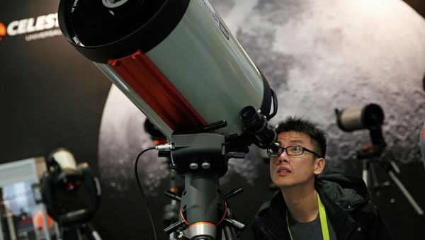 Kei Yuen Hung looks through a telescope at the Celestron booth during the International CES Friday, Jan. 9, 2015, in Las Vegas. Kei Yuen Hung looks through a telescope at the Celestron booth during the International CES Friday, Jan. 9, 2015, in Las Vegas. - Sputnik International