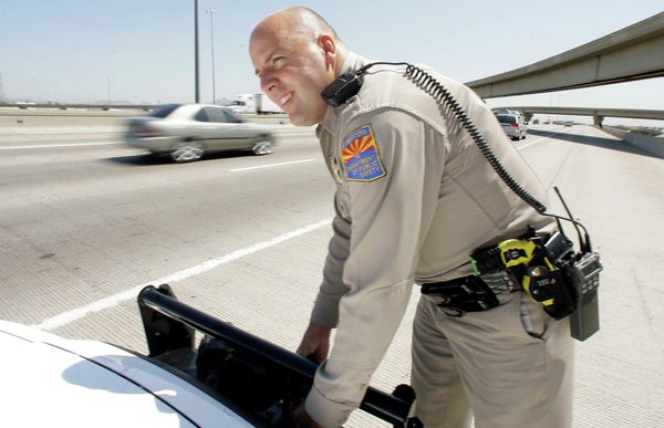 An Arizona Department of Public Safety officer adjusts the infrared license plate scanner mounted on the front bumper of his police cruiser along the I-10 in Phoenix. - Sputnik International