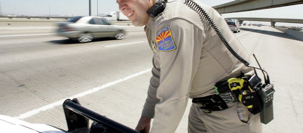 An Arizona Department of Public Safety officer adjusts the infrared license plate scanner mounted on the front bumper of his police cruiser along the I-10 in Phoenix. - Sputnik International