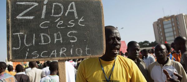 A protester carries a sign reading Zida is Judas Iscariot, referring to coup leader Lt. Col. Yacouba Isaac Zida, in Ouagadougou, capital of Burkina Faso A protester carries a sign reading Zida is Judas Iscariot, referring to coup leader Lt. Col. Yacouba Isaac Zida, in Ouagadougou, capital of Burkina Faso - Sputnik International