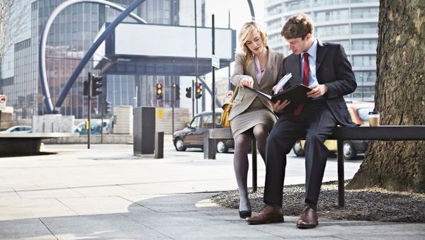 Two businesspeople sitting on railing in city - Sputnik International