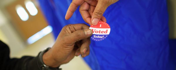 Voting machine operator Robin Coffee-Ruff hands a sticker to a voter who cast his ballot at West Philadelphia High School on U.S. midterm election day morning in Philadelphia, Pennsylvania, November 4, 201 Voting machine operator Robin Coffee-Ruff hands a sticker to a voter who cast his ballot at West Philadelphia High School on U.S. midterm election day morning in Philadelphia, Pennsylvania, November 4, 201 - Sputnik International