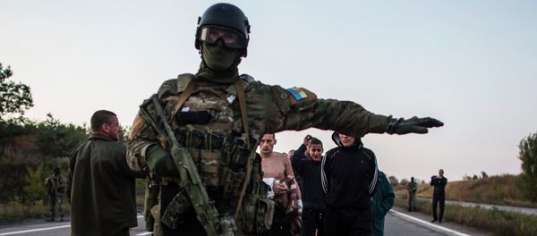 A Ukrainian soldier (C) stands guard as members of the eastern Ukrainian militia, who are prisoners-of-war (POWs), walk along a road as they wait to be exchanged, north of Donetsk, eastern Ukraine, September 28, 2014 A Ukrainian soldier (C) stands guard as members of the eastern Ukrainian militia, who are prisoners-of-war (POWs), walk along a road as they wait to be exchanged, north of Donetsk, eastern Ukraine, September 28, 2014 - Sputnik International