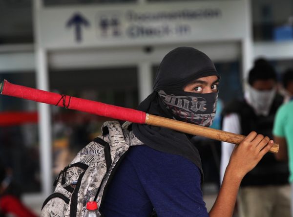 A masked student holds a stick during a protest against the disappearance, and probable murder, of 43 students in the state of Guerrero, at the Acapulco airport in Mexico, Monday, Nov. 10, 2014 - Sputnik International