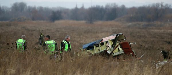MH17 flight recovery team members examine one of the areas of the Malaysia Airlines Flight 17 plane crash - Sputnik International
