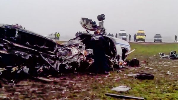 In this image made from video provided by Russian State Television Rossiya, investigators works at the wreckage of a private jet which collided with a snowplow at Vnukovo airport in Moscow, Tuesday, Oct. 21, 2014 - Sputnik International