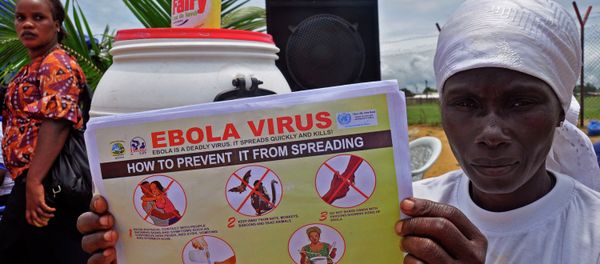 A Liberian woman holds up a pamphlet with guidance on how to prevent the Ebola virus from spreading, in the city of Monrovia, Liberia. - Sputnik International