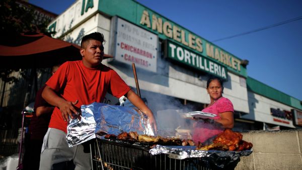 A man cooks meat in a shopping cart in the Westlake area of Los Angeles, home to many Mexican and Central American migrants, California A man cooks meat in a shopping cart in the Westlake area of Los Angeles, home to many Mexican and Central American migrants, California - Sputnik International