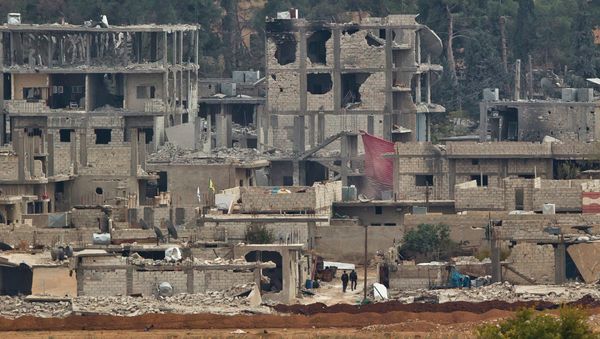 Kurdish fighters walk between damaged buildings - Sputnik International