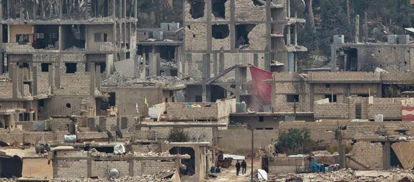 Kurdish fighters walk between damaged buildings Kurdish fighters walk between damaged buildings - Sputnik International