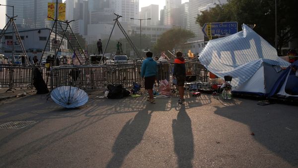Pro-democracy protesters stand at an occupied area before barricades are removed outside government headquarters in Hong Kong's Admiralty district Tuesday, Nov. 18, 2014. Pro-democracy protesters stand at an occupied area before barricades are removed outside government headquarters in Hong Kong's Admiralty district Tuesday, Nov. 18, 2014. - Sputnik International