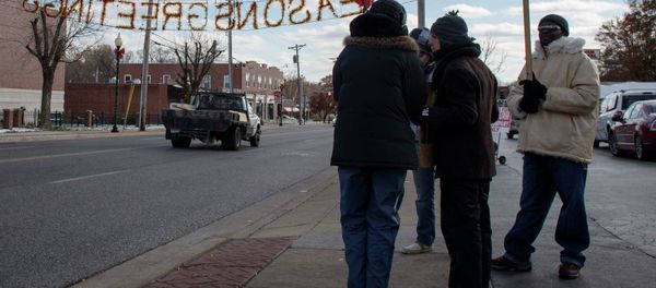 An activist holds up a placard depicting 18-year-old teen Michael Brown An activist holds up a placard depicting 18-year-old teen Michael Brown - Sputnik International