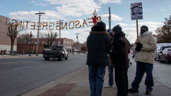 An activist holds up a placard depicting 18-year-old teen Michael Brown - Sputnik International
