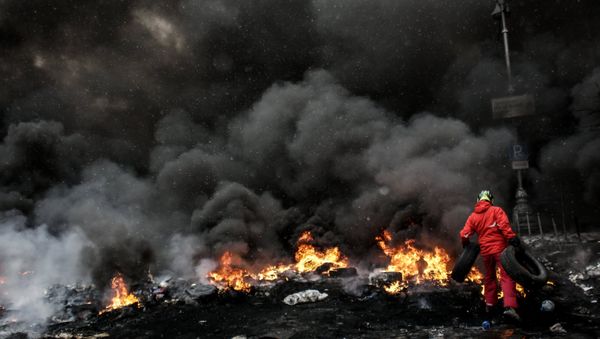 A protester adds tire to the fire in Maidan square in Kiev, Ukraine, Jan 22, 2014 - Sputnik International