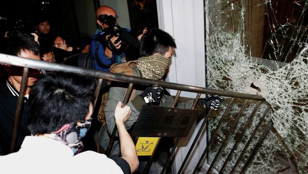 Masked pro-democracy protesters try to break with a fence a glass window of the Legislative Council in Hong Kong early November 19, 2014 Masked pro-democracy protesters try to break with a fence a glass window of the Legislative Council in Hong Kong early November 19, 2014 - Sputnik International