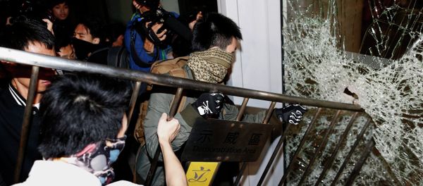 Masked pro-democracy protesters try to break with a fence a glass window of the Legislative Council in Hong Kong early November 19, 2014 - Sputnik International