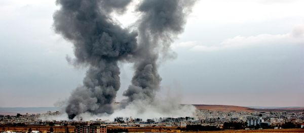 Smoke rises from the Syrian city of Kobani, following airstrikes by the US led coalition, seen from a hilltop outside Suruc, on the Turkey-Syria border Monday, Nov. 17, 2014 - Sputnik International