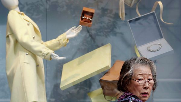 A woman walks past a display window of a luxury store - Sputnik International
