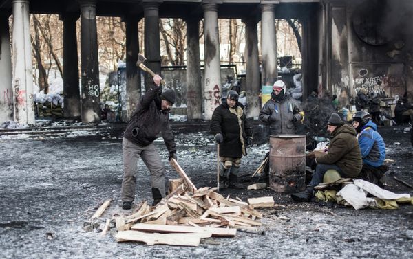 An opposition supporter chops firewood near a barricade on Grushevskogo Street in Kiev. An opposition supporter chops firewood near a barricade on Grushevskogo Street in Kiev. - Sputnik International