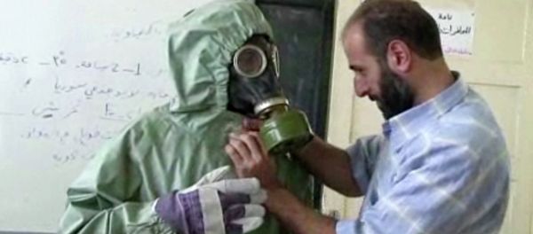 Volunteer adjusting a gas mask and protective suit on a student during a classroom session a on how to respond to a chemical weapons attack in Aleppo, Syria Volunteer adjusting a gas mask and protective suit on a student during a classroom session a on how to respond to a chemical weapons attack in Aleppo, Syria - Sputnik International