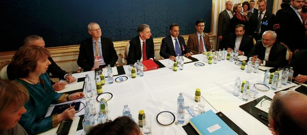 EU envoy Catherine Ashton (L), Britain's Foreign Secretary Philip Hammond (C) and Iranian Foreign Minister Javad Zarif sit at a table during talks in Vienna November 21, 2014 - Sputnik International