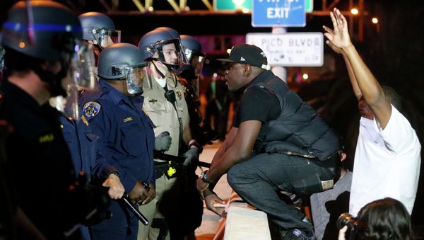 A protester faces off against a line of police on the 110 freeway during a demonstration in Los Angeles, California following the grand jury decision in the shooting of Michael Brown in Ferguson A protester faces off against a line of police on the 110 freeway during a demonstration in Los Angeles, California following the grand jury decision in the shooting of Michael Brown in Ferguson - Sputnik International
