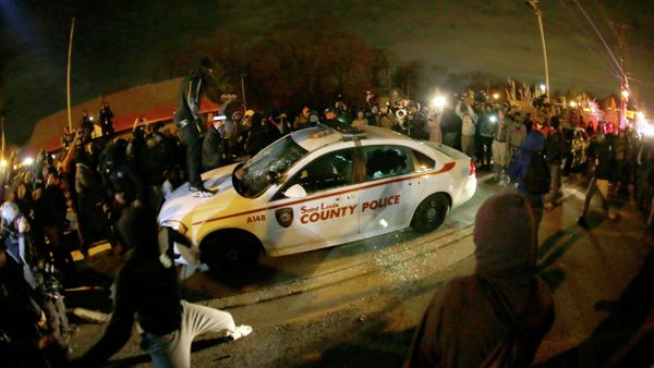 A protester squirts lighter fluid on a police car as the car windows are shuttered near the Ferguson Police Department after the announcement of the grand jury decision not to indict police officer Darren Wilson in the fatal shooting of Michael Brown, an unarmed black 18-year-old in Ferguson A protester squirts lighter fluid on a police car as the car windows are shuttered near the Ferguson Police Department after the announcement of the grand jury decision not to indict police officer Darren Wilson in the fatal shooting of Michael Brown, an unarmed black 18-year-old in Ferguson - Sputnik International