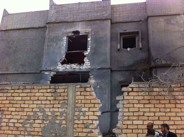 Men stand beside a damaged building near Mitiga airport in Libya's capital Tripoli - Sputnik International